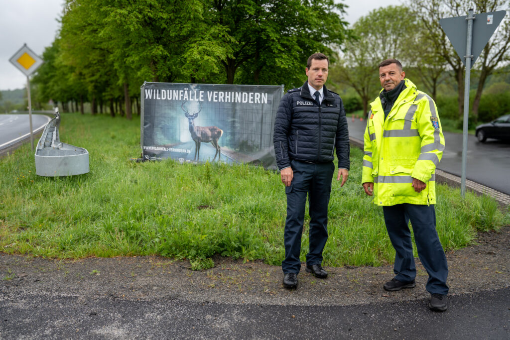 Steffen Heil (Presse- und Öffentlichkeitsarbeit) und POK Christof Kuras von der Polizeidirektion Vogelsberg vor einem Bauzaunbanner des Landesjagdverbandes Hessen am Kontrolltag. Foto: Markus Stifter