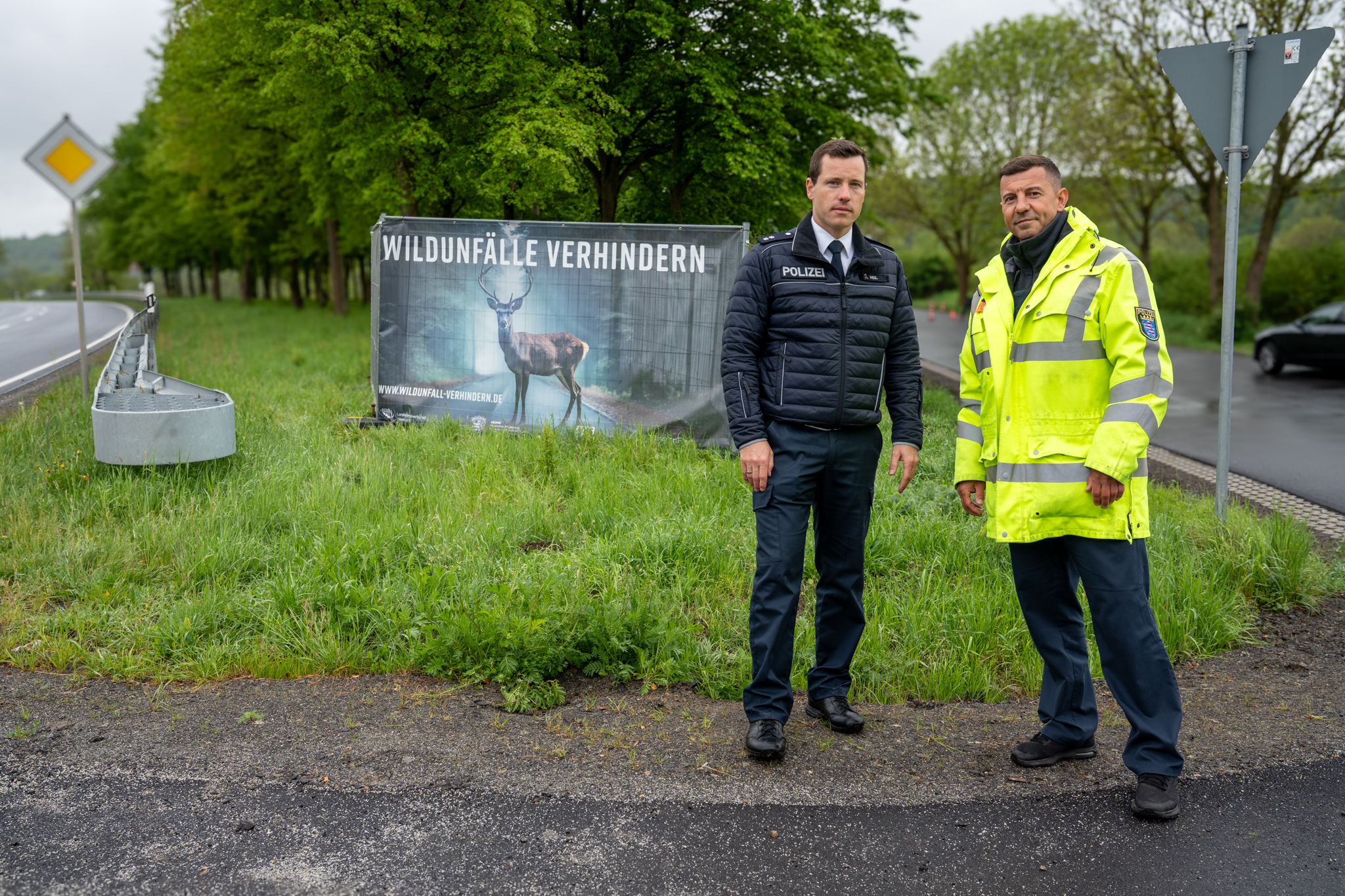 Steffen Heil (Presse- und Öffentlichkeitsarbeit) und POK Christof Kuras von der Polizeidirektion Vogelsberg vor einem Bauzaunbanner des Landesjagdverbandes Hessen am Kontrolltag. Foto: Markus Stifter